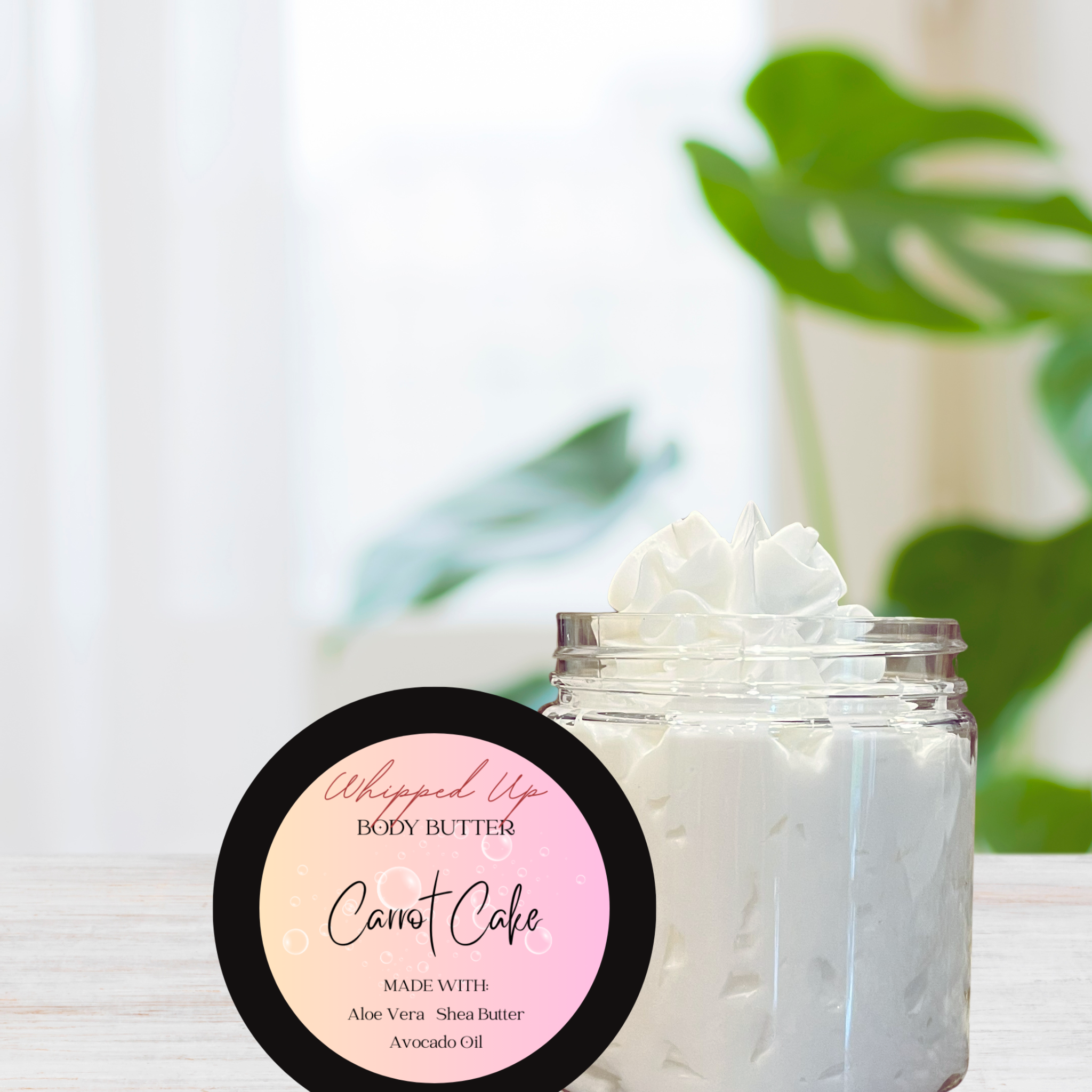 Jar of Carrot Cake body butter with a pink label on a blurred natural background